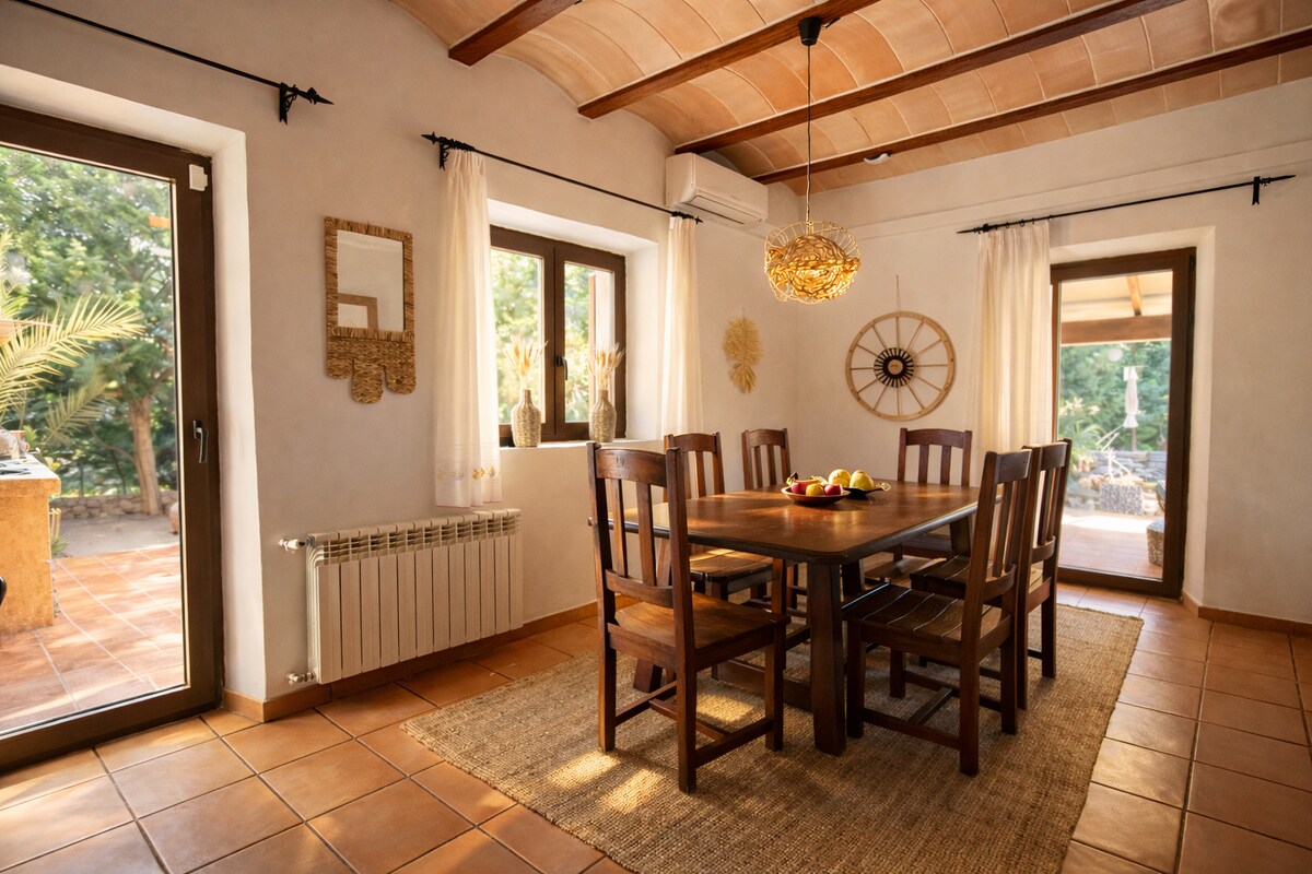 Esszimmer mit massivem Holztisch, Gewölbedecke und Türen zum Innenhof