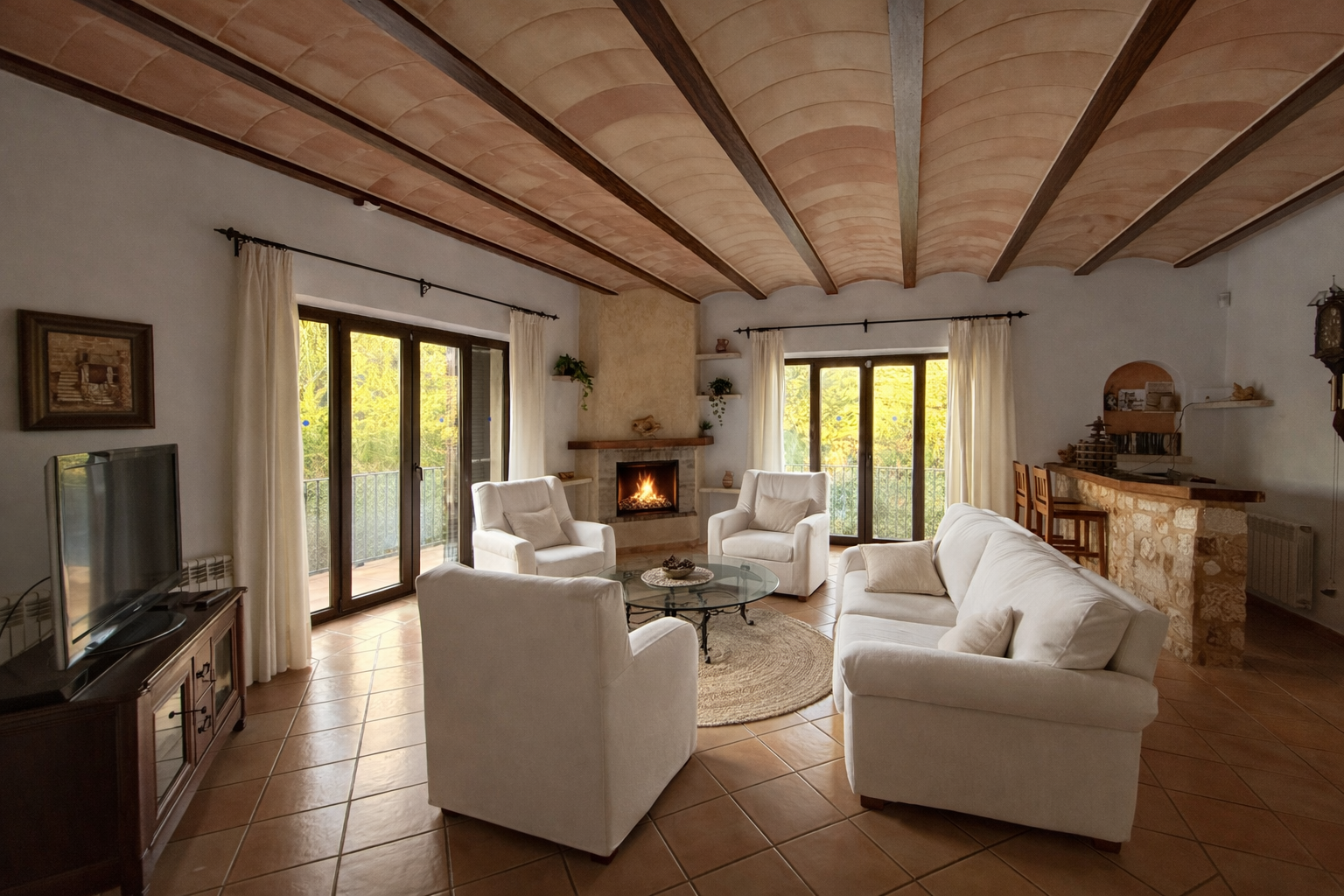 Wohnzimmer der Finca Es Castell mit Kamin, heller Sitzgruppe und Terrakotta-Gewölbedecke