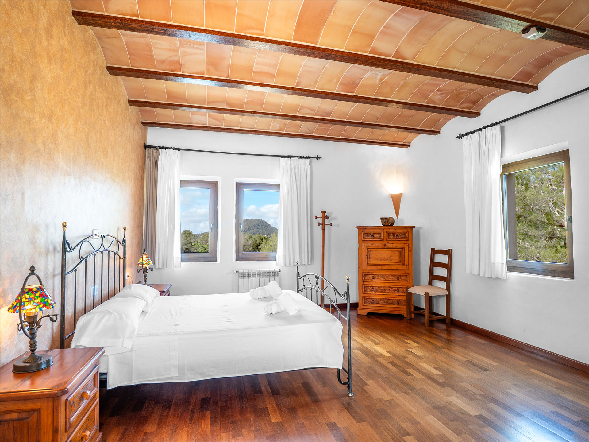 Schlafzimmer mit Doppelbett, Holzboden und Terrakotta-Gewölbedecke