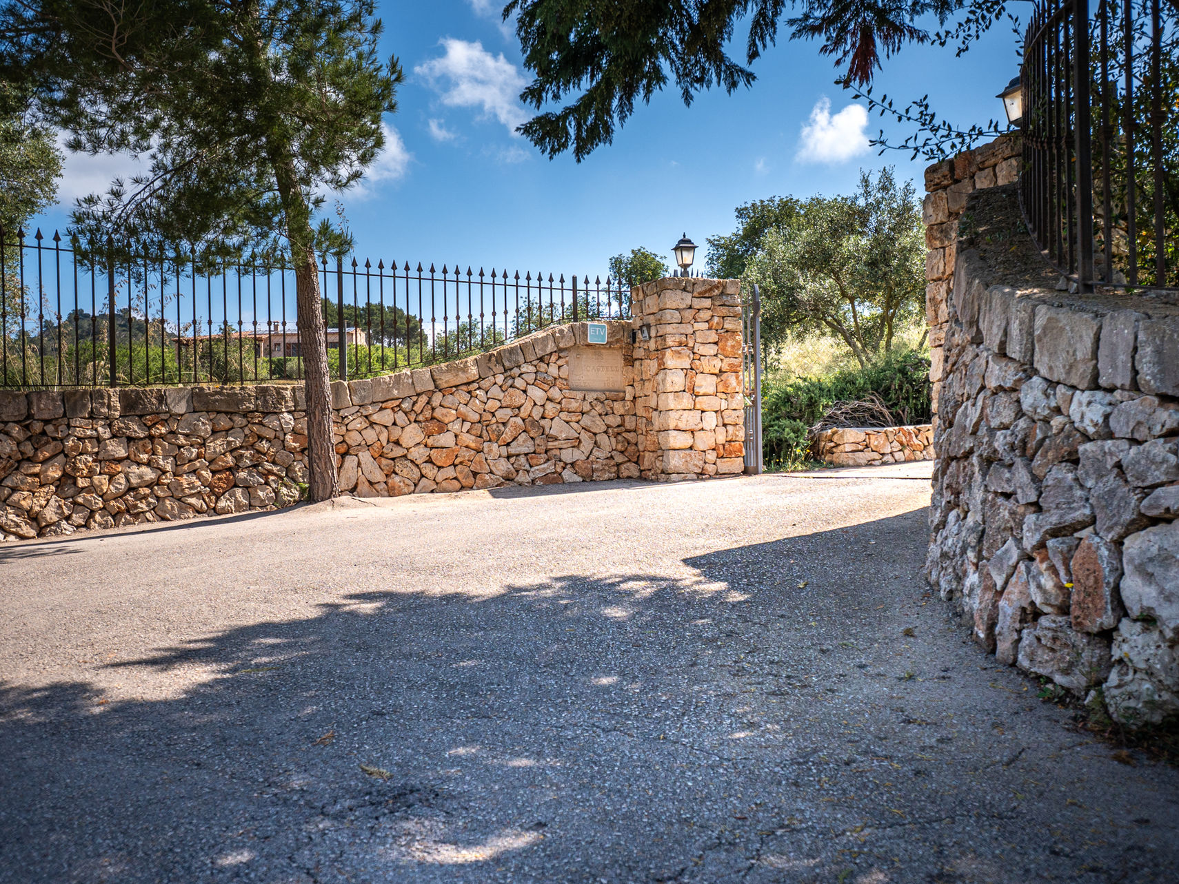 Einfahrtstor der Finca Es Castell mit Natursteinmauer
