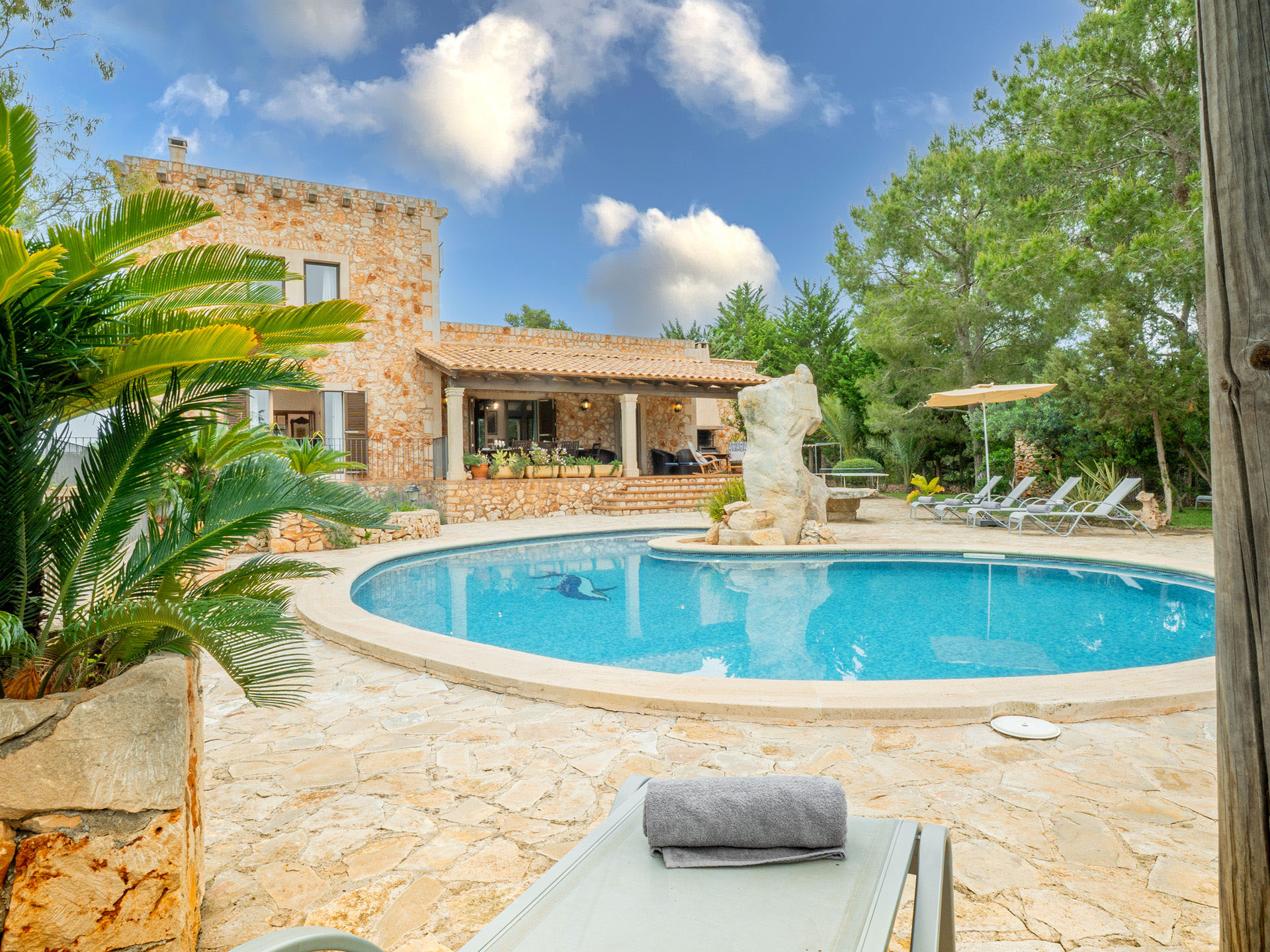 Privater Pool der Finca Es Castell mit Sonnenliegen und Olivenbäumen