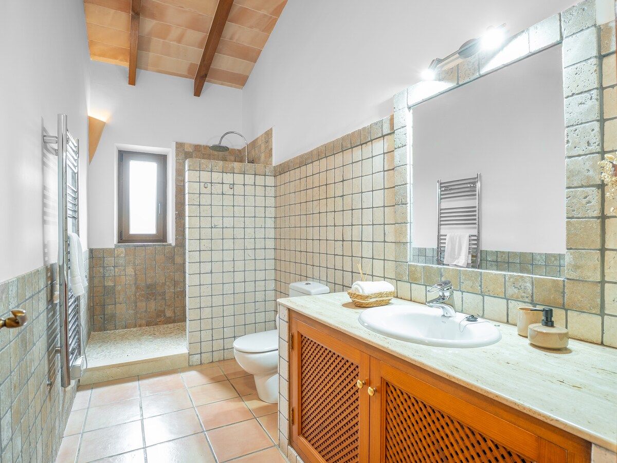Badezimmer mit gemauerter Walk-in-Dusche, Holzbalkendecke und Waschtisch